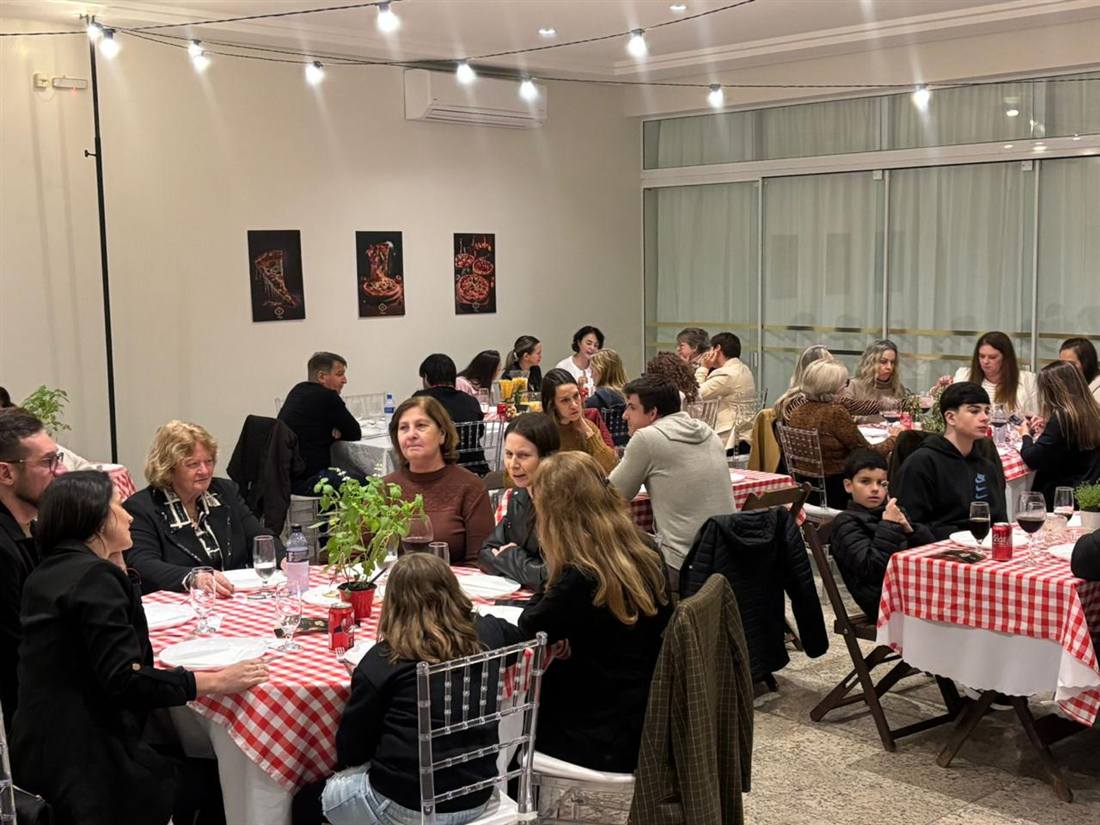 Salão da Noite das Pizzas com toalhas xadrez e convidados