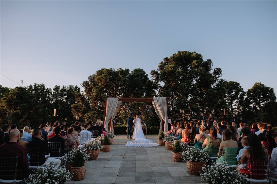 Cerimônia de casamento ao ar livre, com os convidados no gramado