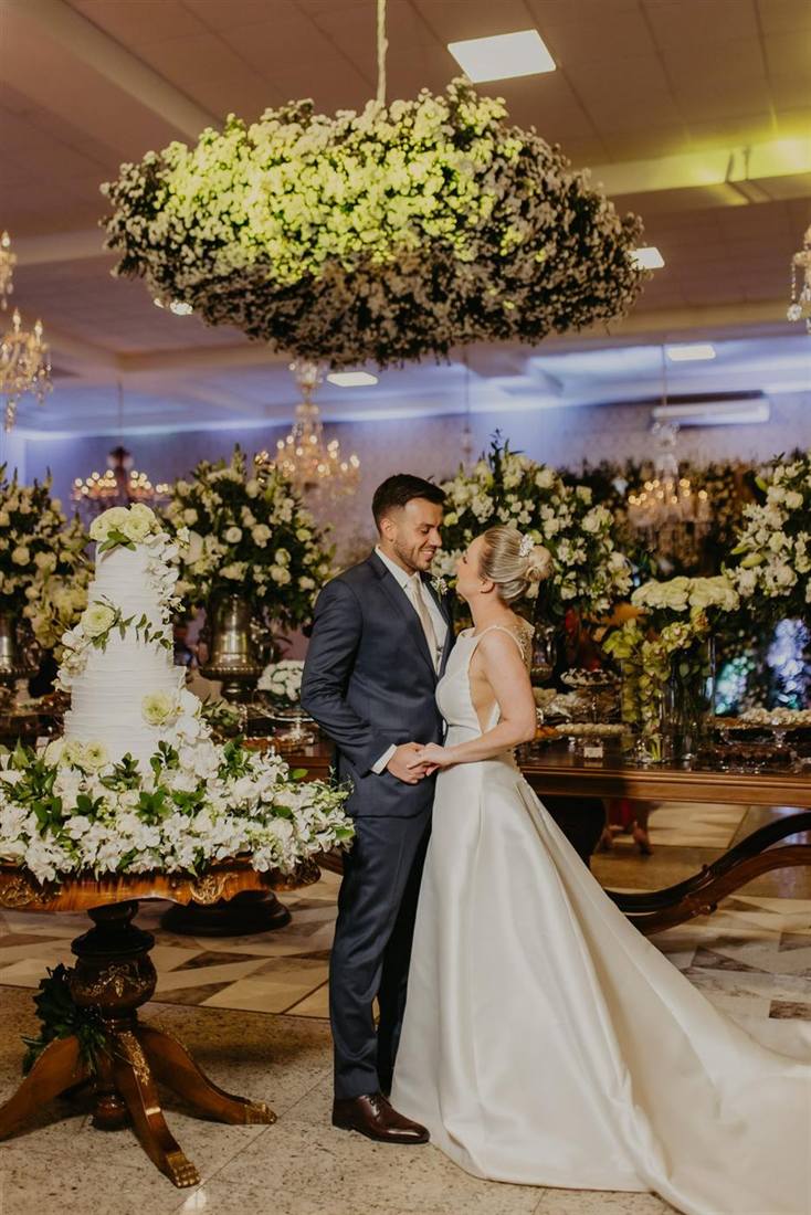 Noivos dançando sob uma decoração de flores