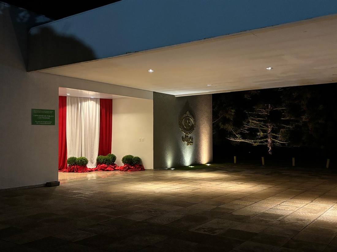 Entrada coberta do Gabbana Jardins à noite, com o logo iluminado