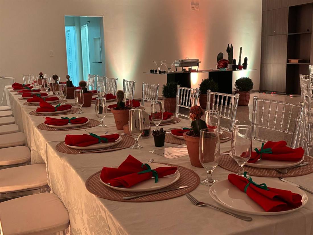 Salão Flor de Lis montado para jantar, com mesa comprida, mesas redondas e buffet ao fundo