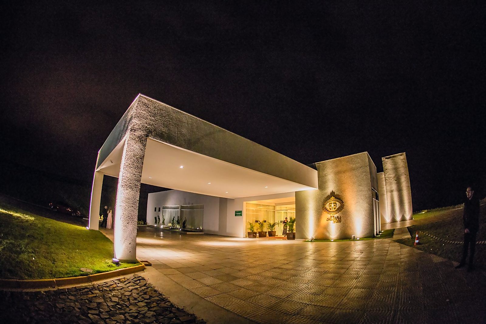 Entrada do Gabbana Jardins à noite, com a cobertura de chegada e a fachada iluminadas
