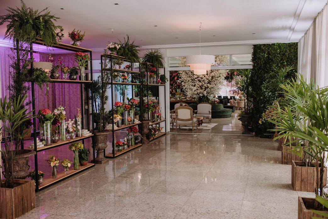Hall de entrada com piso de mármore e composições de flores