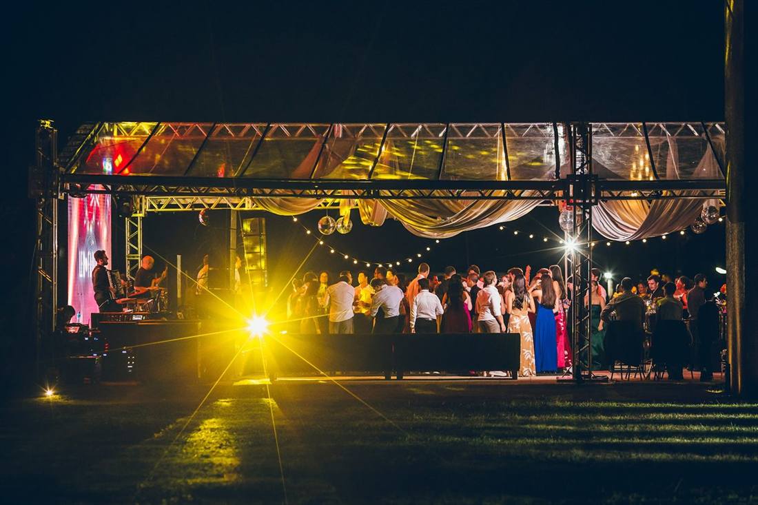 Tenda iluminada no gramado durante uma festa à noite